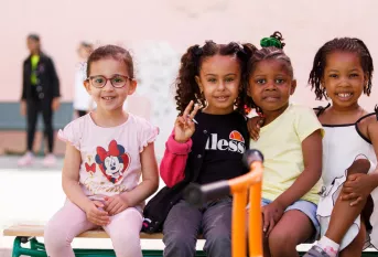 4 petites filles assises sur un banc